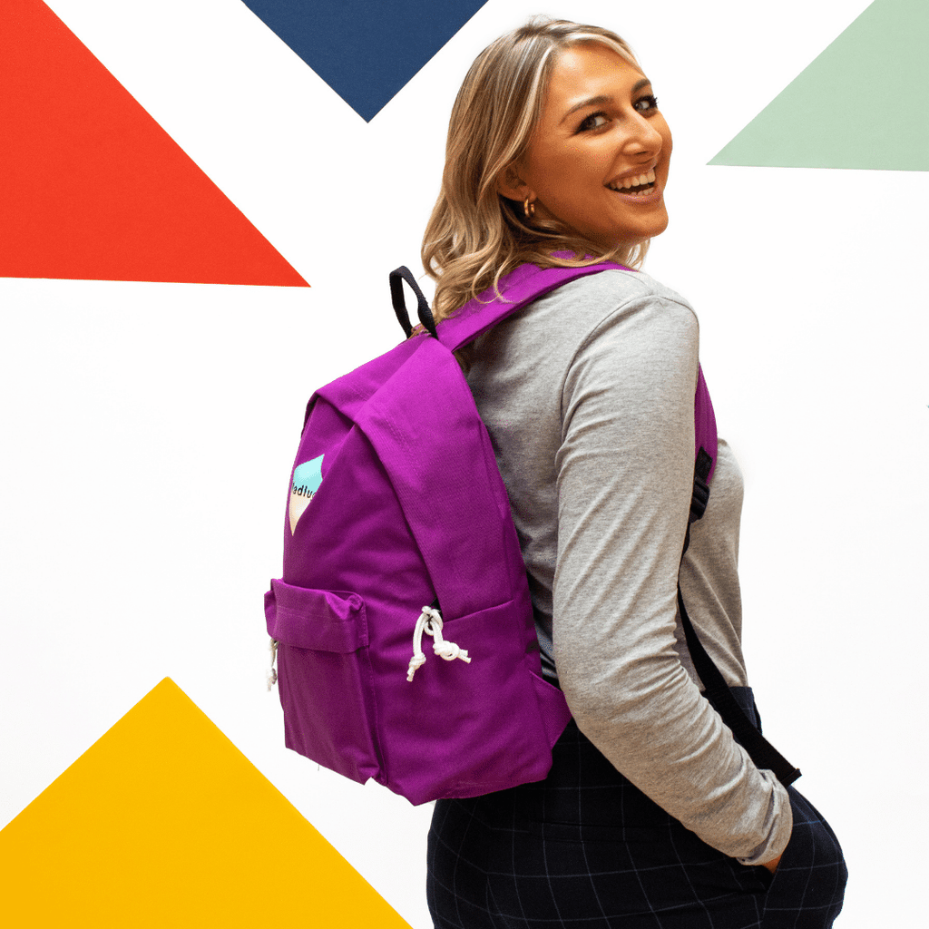 Madlug Classic Backpack in Magenta. Female model side view.