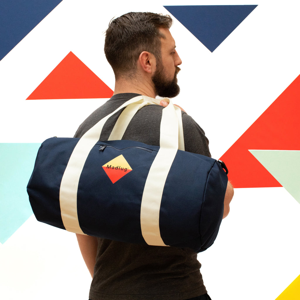 Madlug Duffel Bag in Navy. Modelled showing rear view.