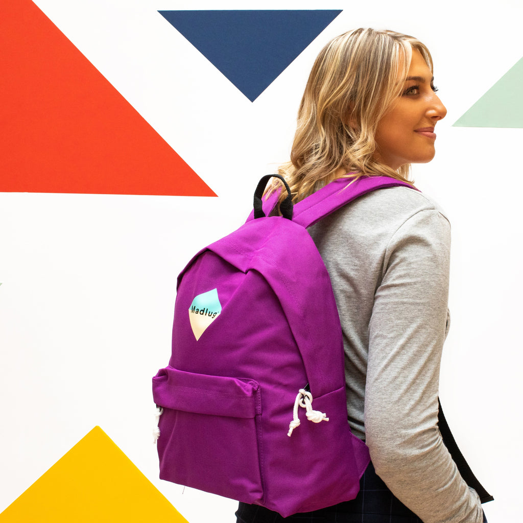 Madlug Classic Backpack in Magenta. Female model side view.