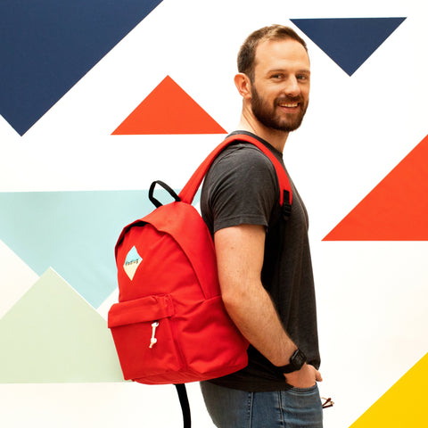 Madlug Classic Backpack in Red. Male model side view.