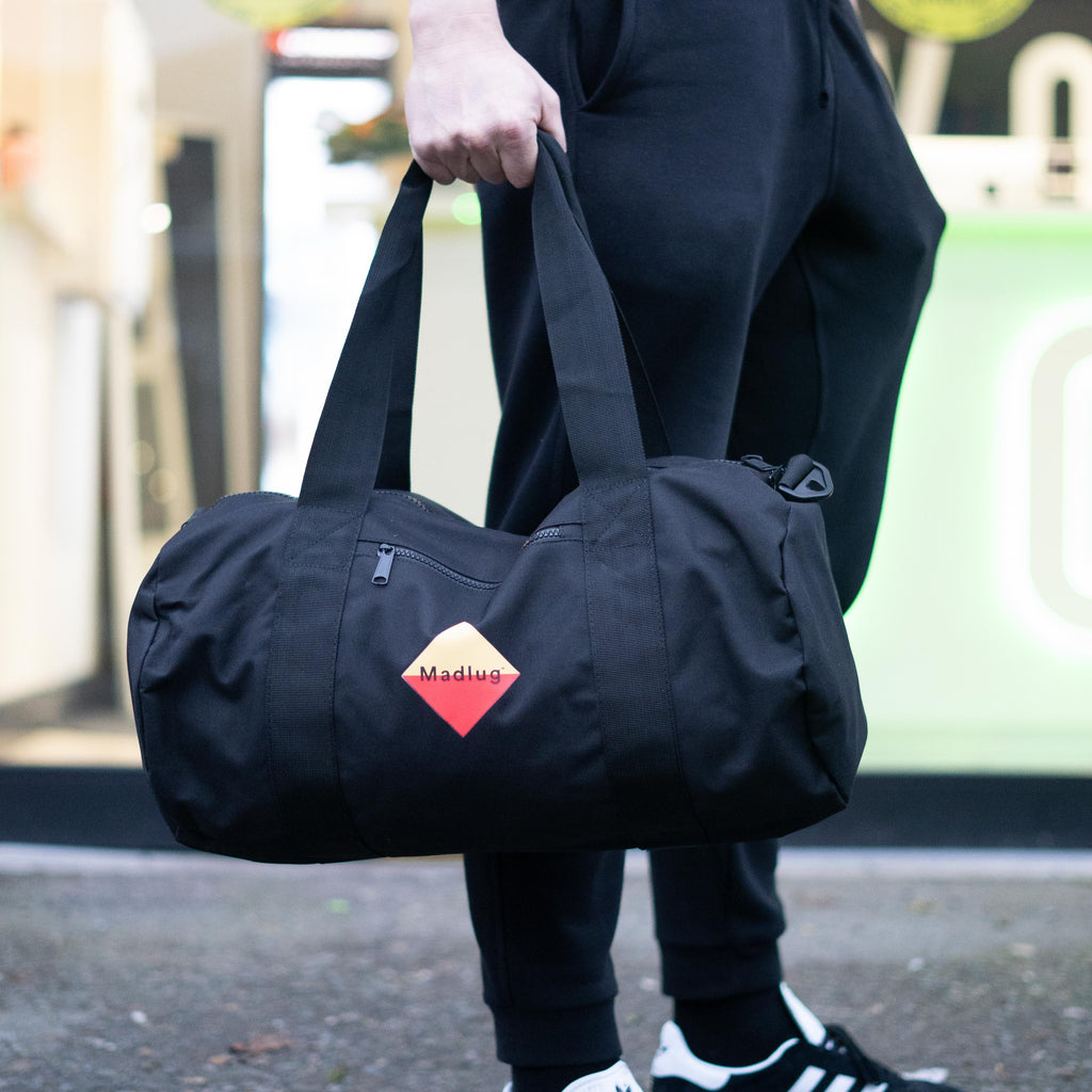 Madlug Duffel Bag in Navy. Modelled shoing side view.