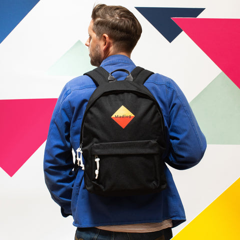 Madlug Classic Backpack in Black. Male model rear view.